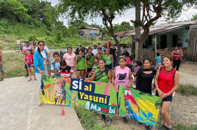 Grupo de pessoas segundo faixa contendo o texto "Sim para Yasuní Manabí"