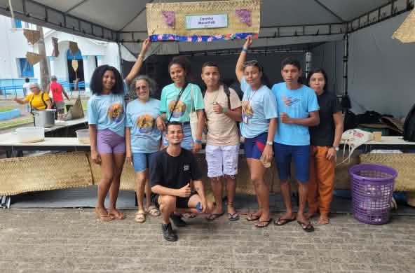 Oito jovens, cinco mulheres e um homem, aparecem perfilados e sorrindo para a foto. Quatro deles usam camisetas iguais do congresso nacional da CPT