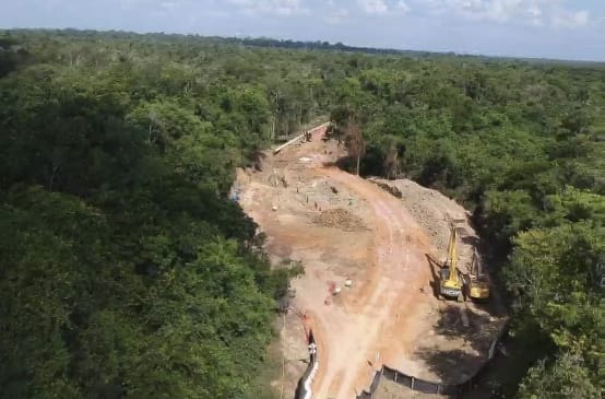 Foto área das obras de construção do mineroduto para transporte de bauxita na floresta equatorial, com escavadeiras contendo terra revirada e pedaços dos tubos