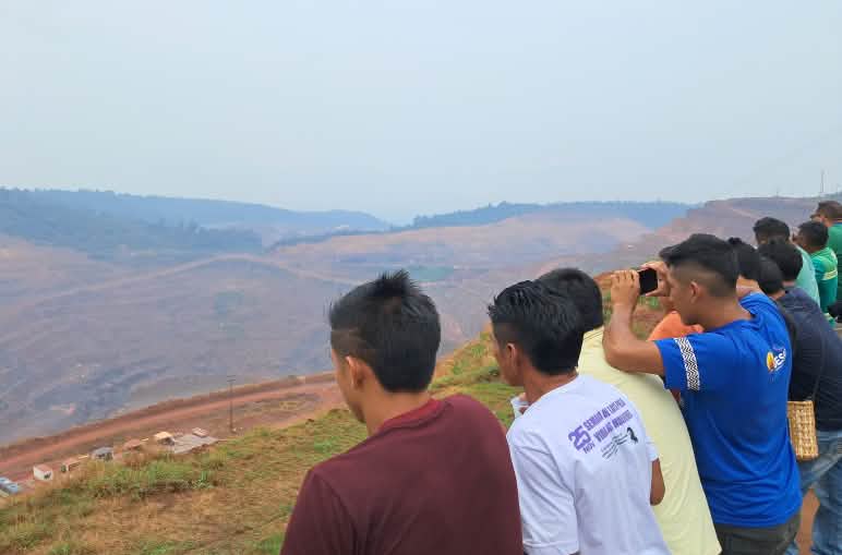 Professores e alunos Awa Guajá conhecem e fazem registros de uma das minas da Vale S.A., em Parauapebas, no Pará Mais de dez pessoas observam, do alto de uma montanha, a destruição das minas abertas pela empresa Vale