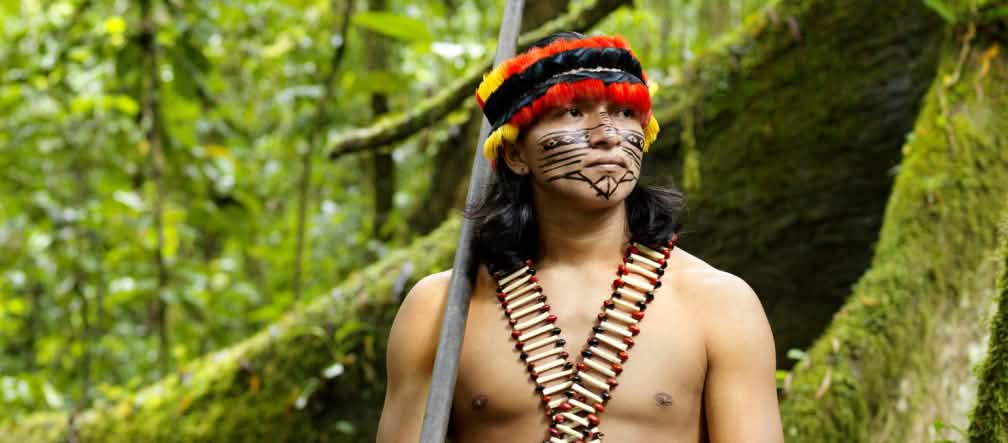 A Amazônia dá aos nativos tudo que eles precisam para viver Representante de um povo da floresta com zarabatana, de rosto pintado e enfeitado com uma pena