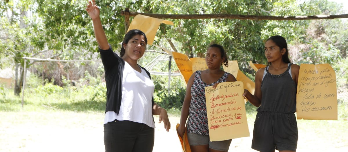 Três participantes de um workshop do Movimento Xingu Vivo para Sempre seguram pôsteres