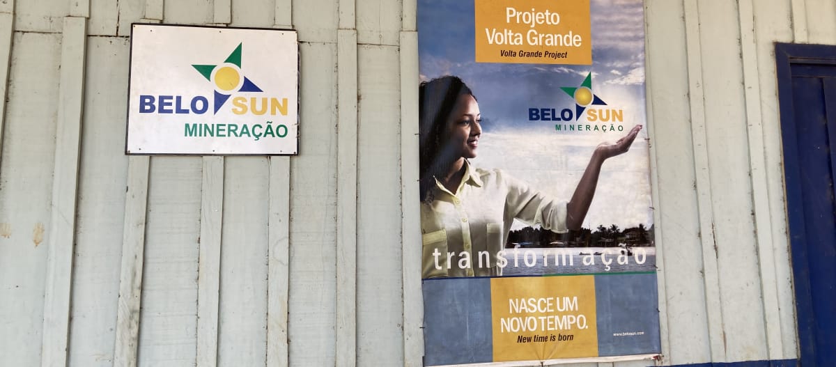 Uma placa da empresa de mineração Belo Sun e um pôster com propaganda da empresa na parede de uma cabana de madeira