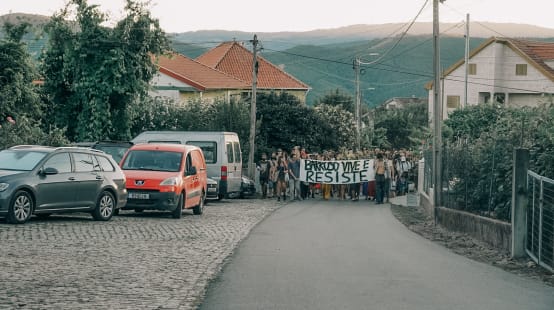 Participantes do Acampamento em Defesa do Barroso, em Covas do Barroso, Portugal, se manifestam pelos passeios da aldeia com uma faixa na qual se lê "Barroso vive e resiste"