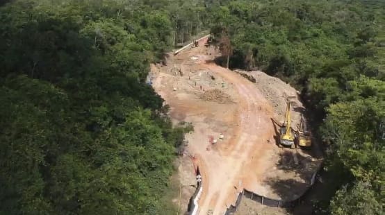 Foto área das obras de construção do mineroduto para transporte de bauxita na floresta equatorial, com escavadeiras contendo terra revirada e pedaços dos tubos