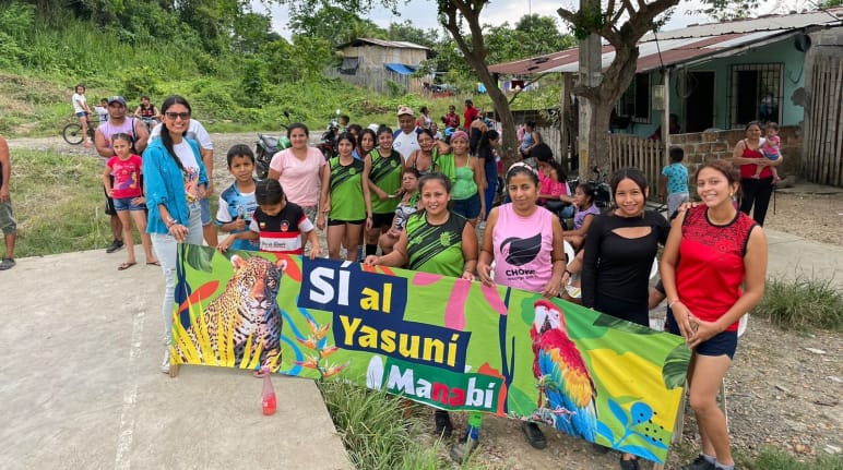 Grupo de pessoas segundo faixa contendo o texto "Sim para Yasuní Manabí"