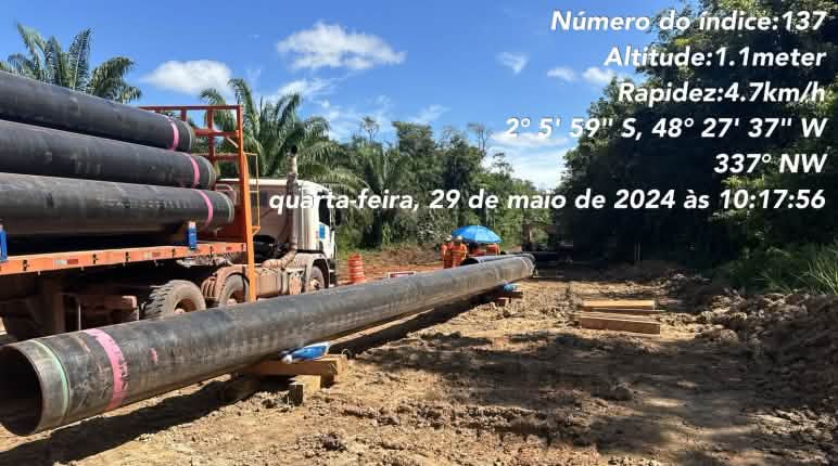 Obras do mineroduto da Hydro para transportar bauxita na Amazônia brasileira (Pará) Um caminhão com seções de tubulação de dutos e seções de tubulação já colocadas no chão em um local de construção na floresta tropical