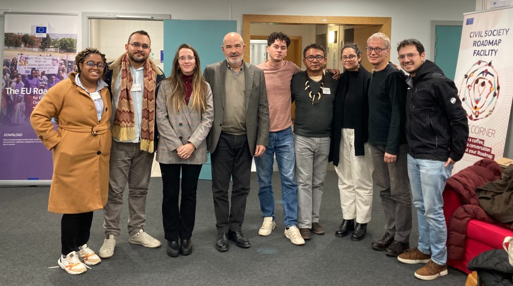 Foto de grupo de 9 pessoas à frente da entrada de um escritório da Comissão Européia l