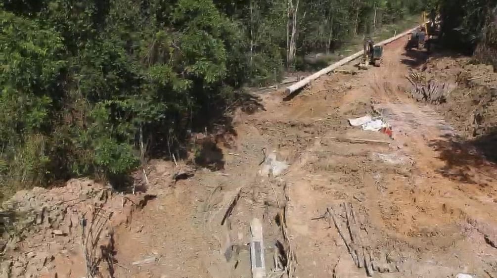 Foto área das obras de construção do mineroduto para transporte de bauxita na floresta equatorial, com escavadeiras contendo terra revirada e pedaços dos tubos