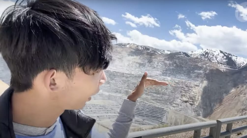 Jovem observando uma grande mina a céu aberto